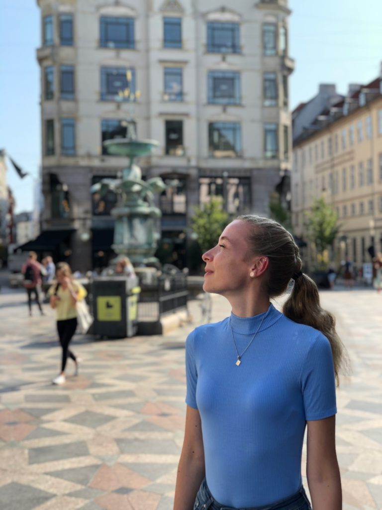 Pia-mingenbach-professional-career-marketing-commitment-hobby-passion-interests-cultural-travel-tourism-city-trip-Copenhagen-Danmark-photo-blue-shirt-looking-up